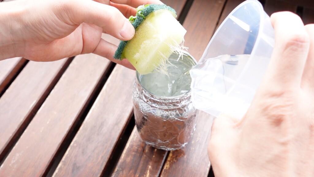 養液を大葉の容器に入れている画像